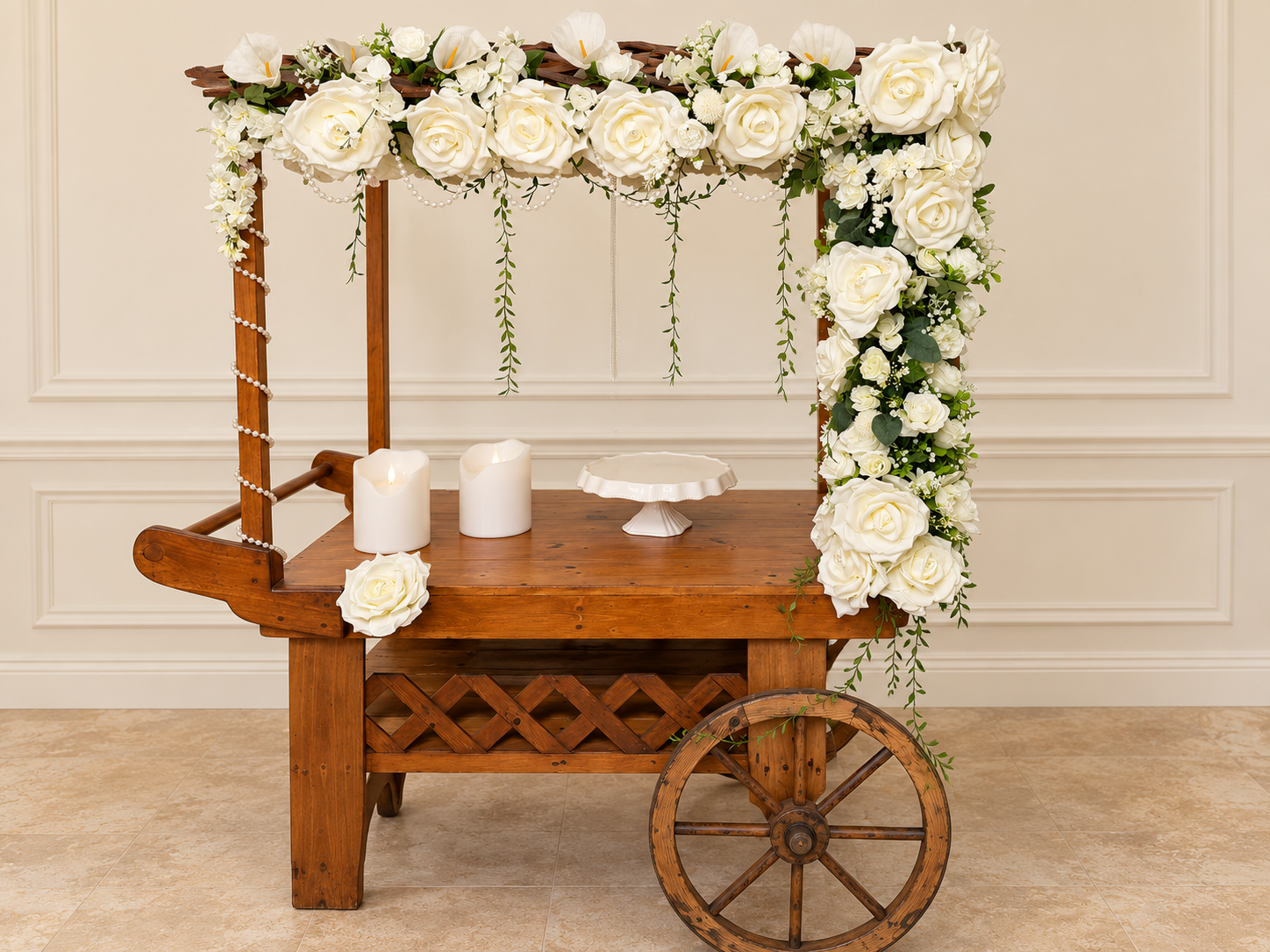 Wooden serving cart decorated with white flowers, candles and an empty display stand